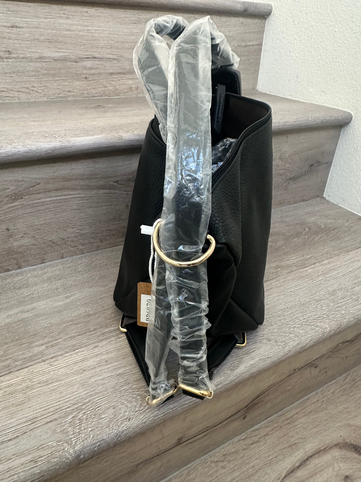 Black asymmetrical coverable handbag to backpack